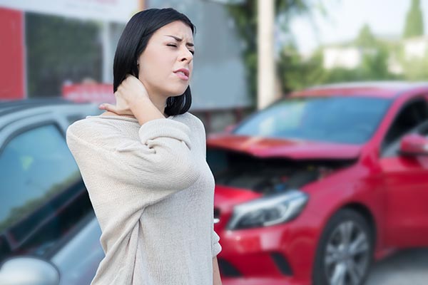 Mujer con dolor de cuello después de un accidente de carro