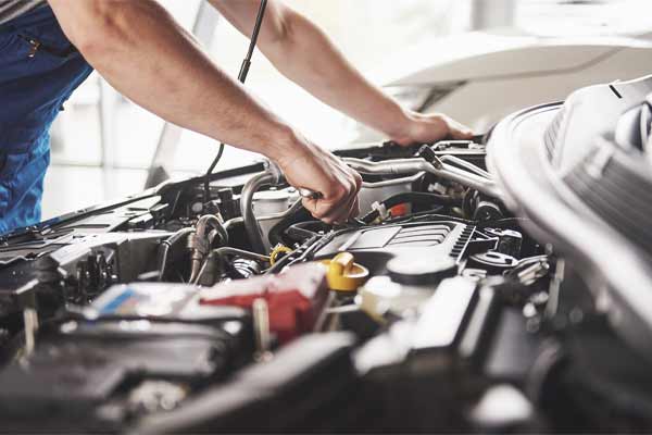An image of a man working on a car engine